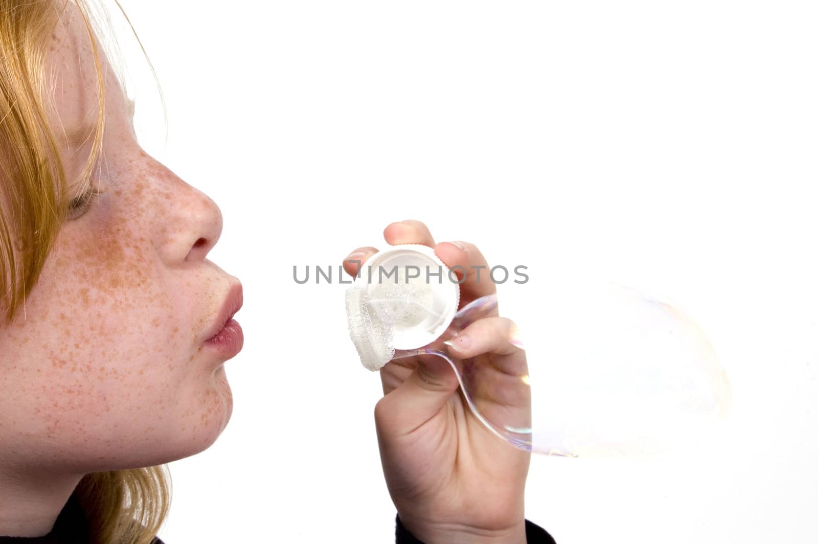 little girl is blowing bubbles isolated on white