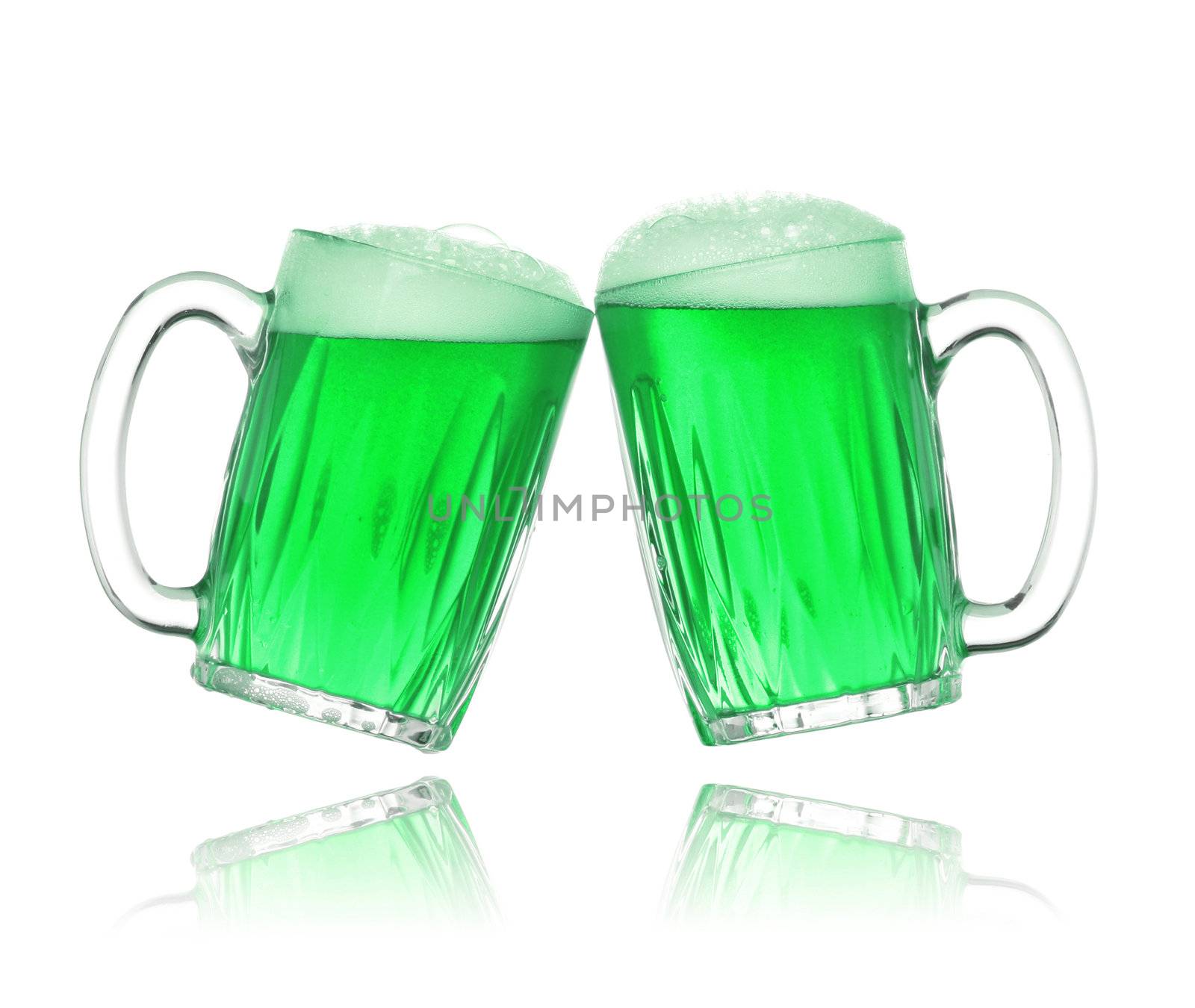 Pair of green beer glasses making a toast. St. Patrick's Day beer splash