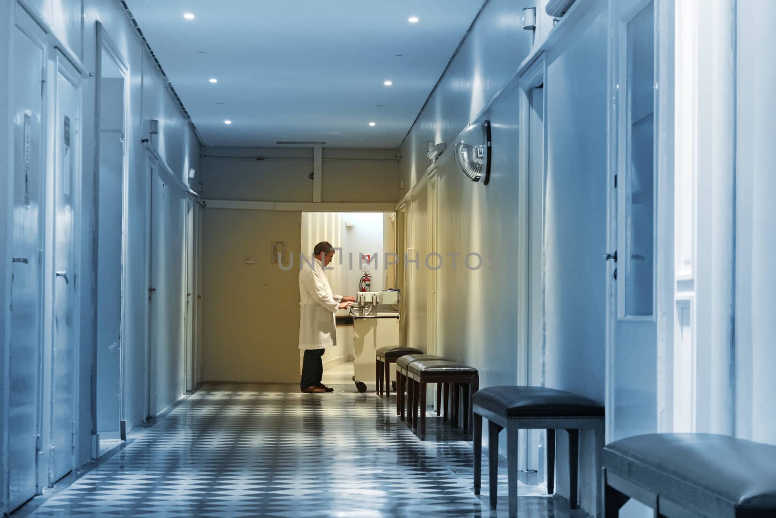 Doctor working at the end of a hospital hall