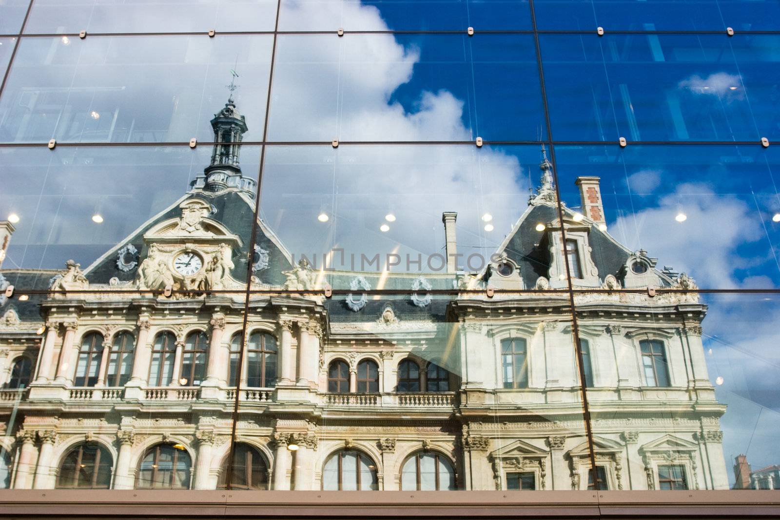 Old house reflected in modern office building glass wall