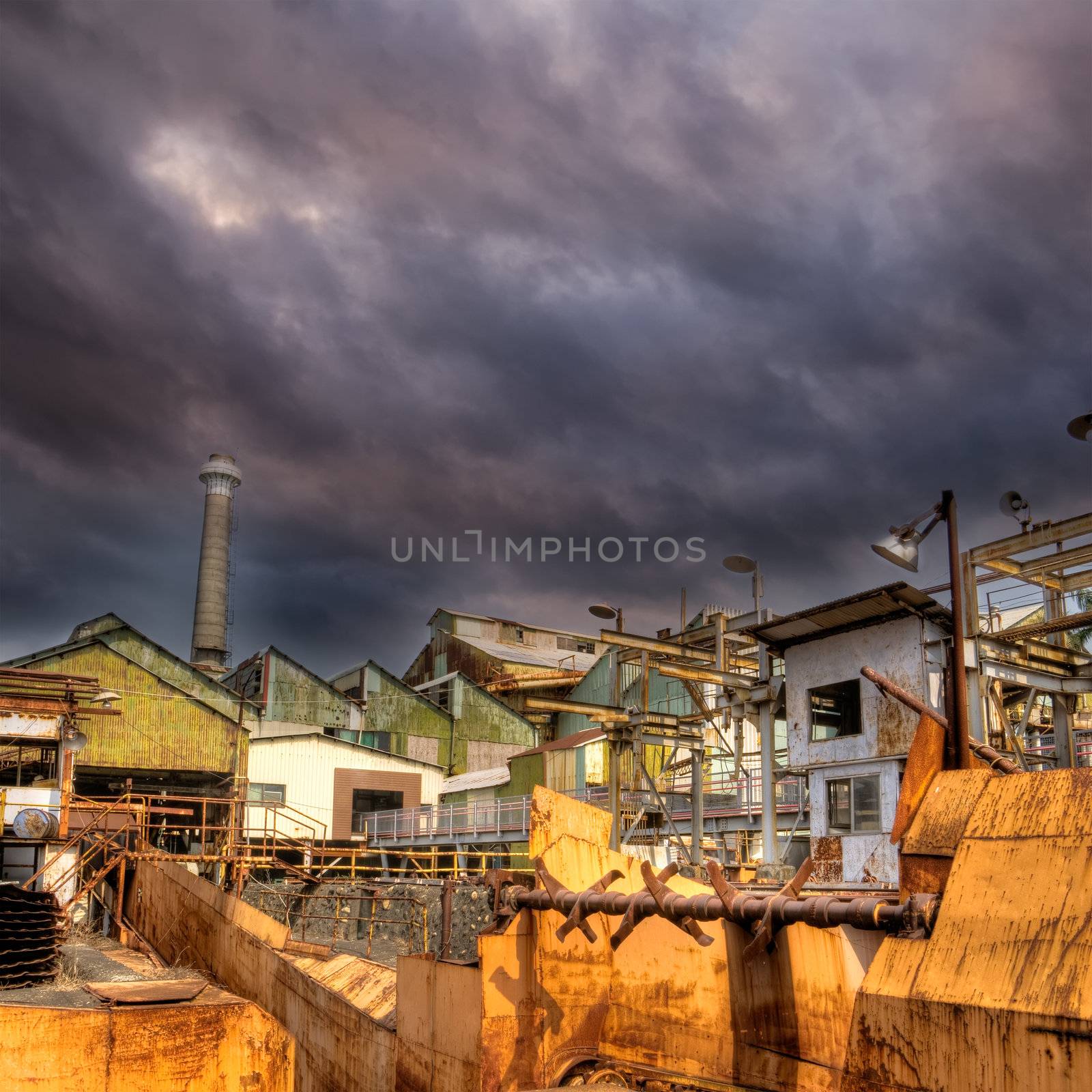 Factory of abandonment with dramatic cloud in sky.