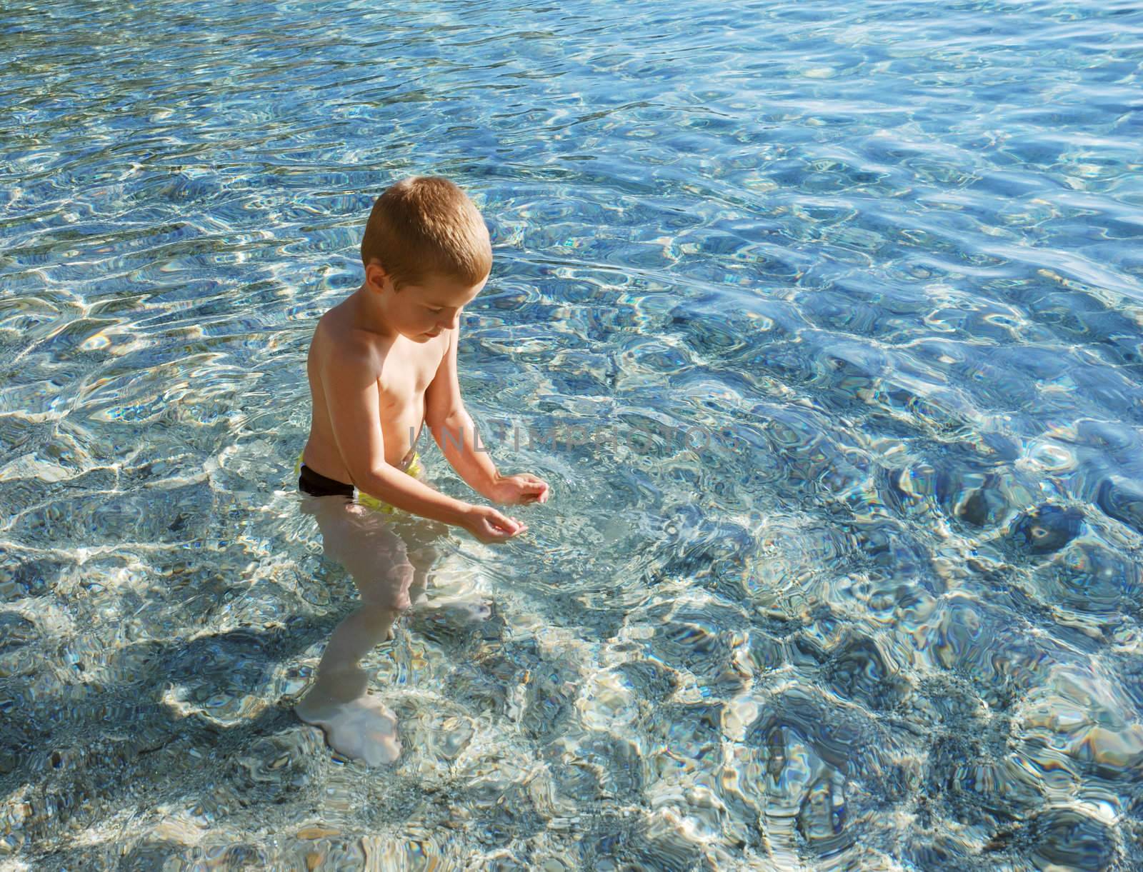 a boy is smiling and playing in a water