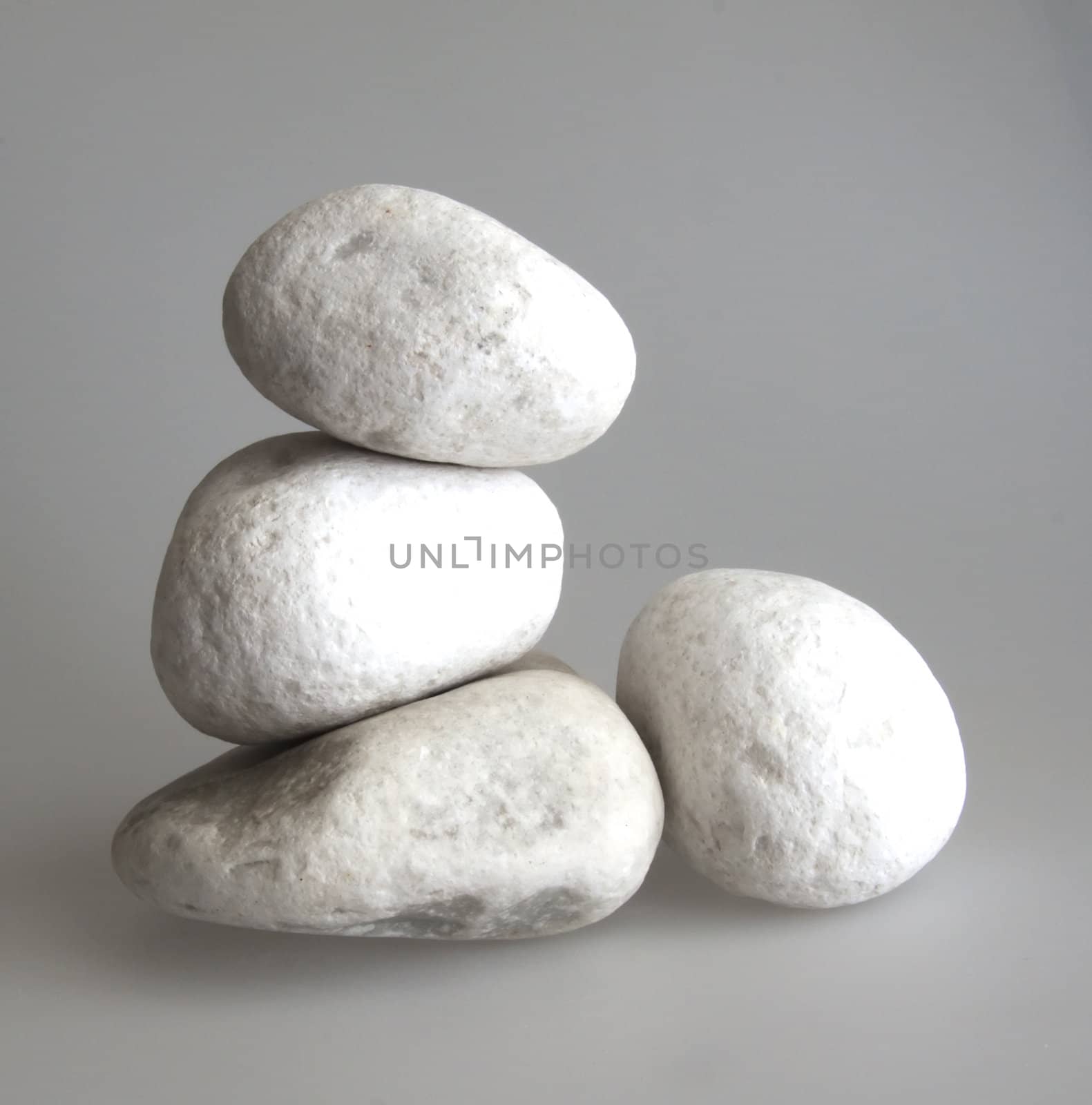 Four big white stones over gray background