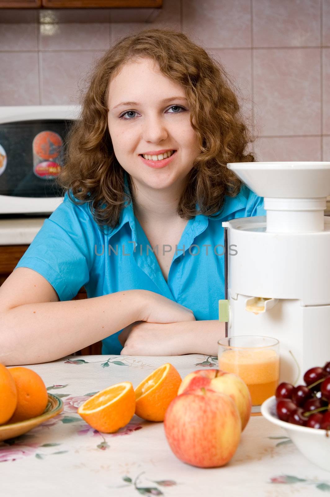 Smiling girl with blender and fruits on home kitchen