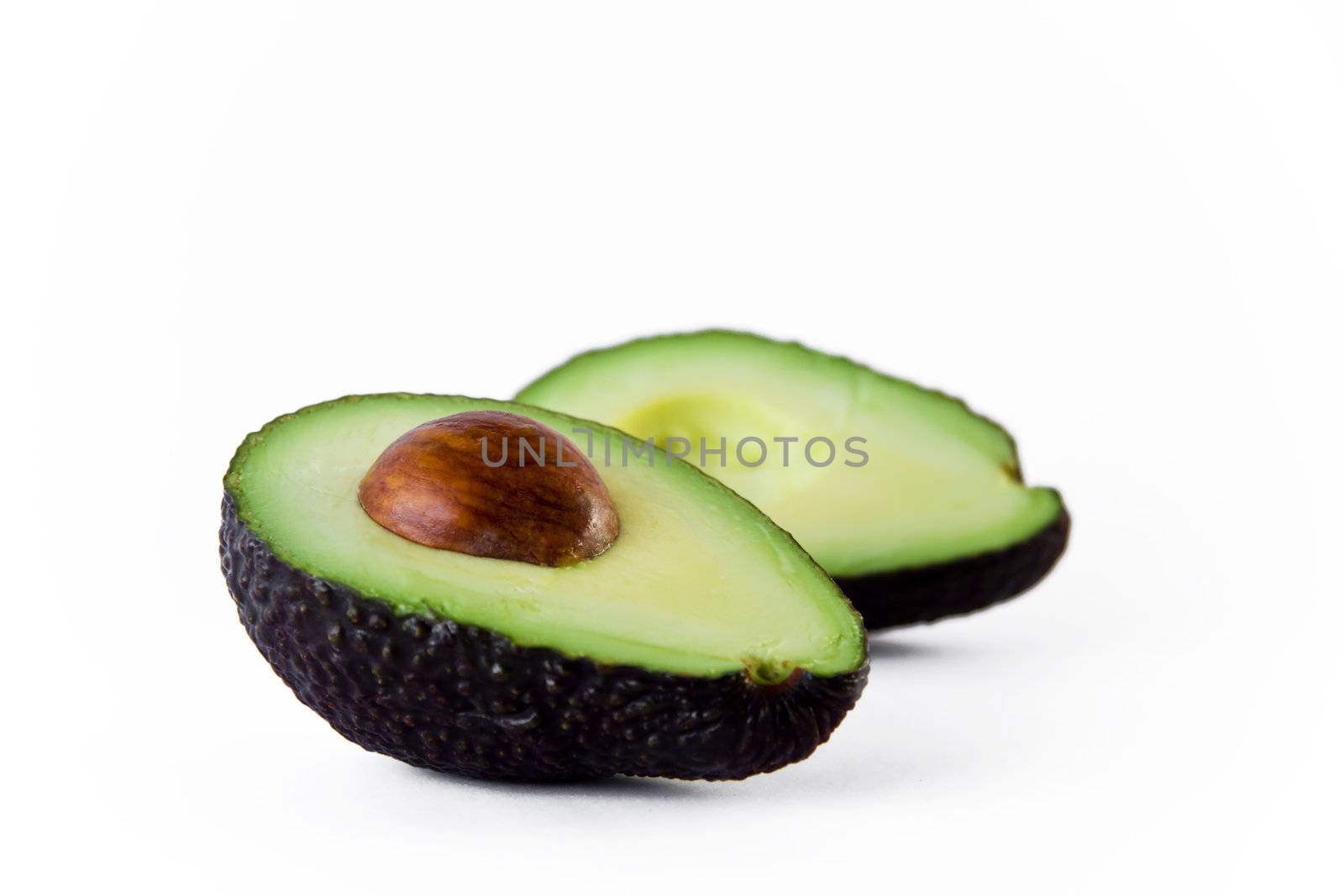 A green ripe avocado cut in half