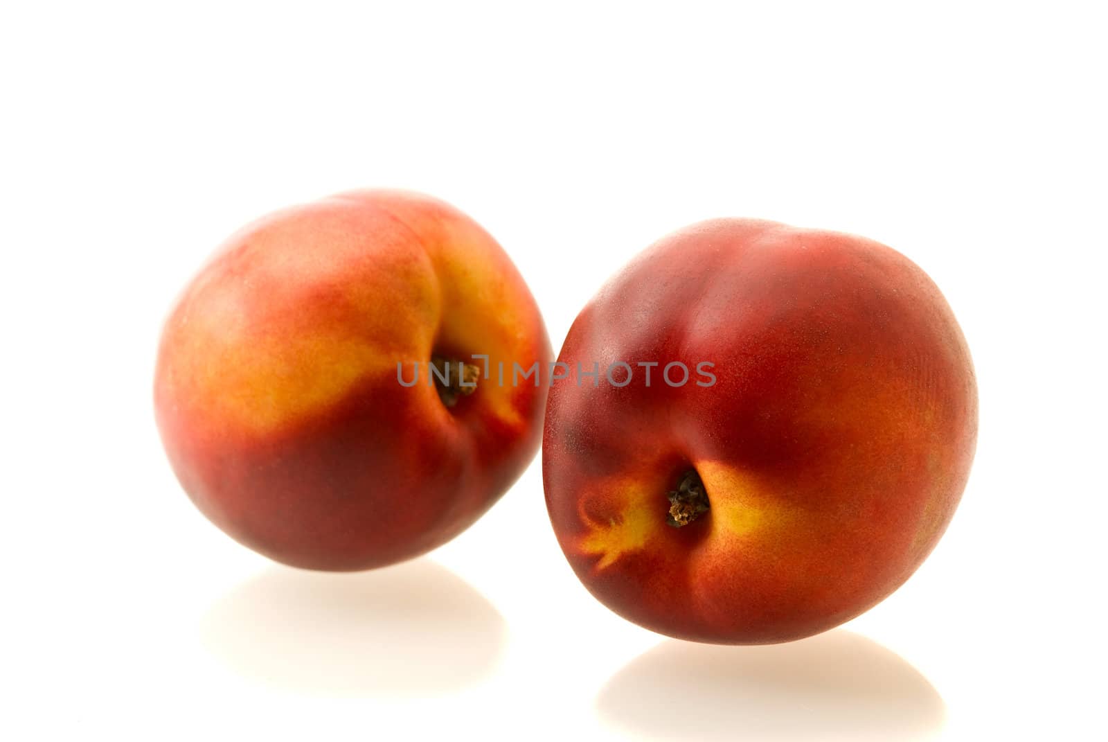 two ripe fresh nectarines over white background