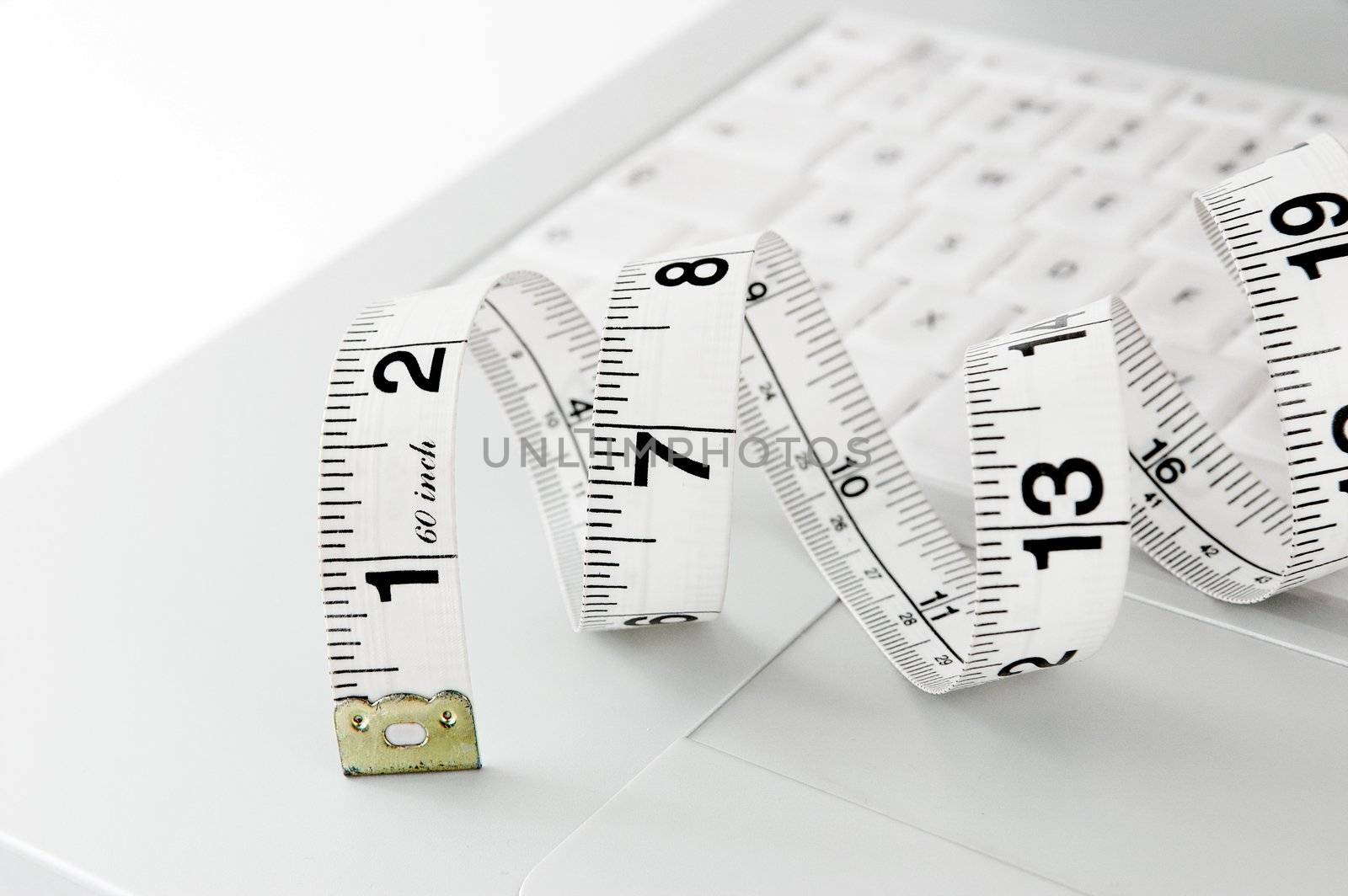 measuring tape on laptop keyboard