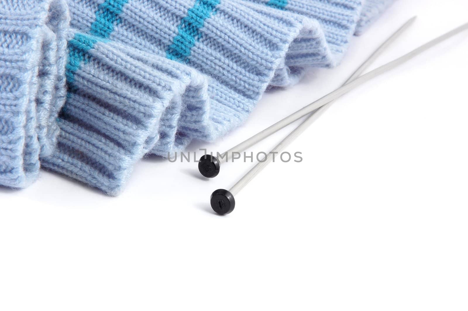 knitted jumper with needles on white background