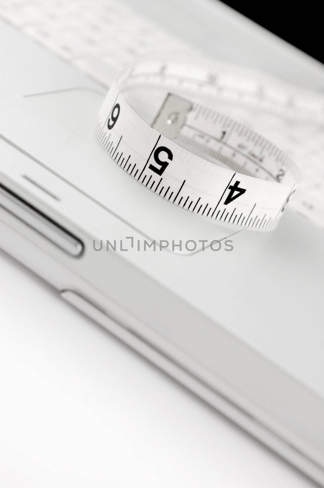 Measuring tape on keyboard of white laptop. Copy space. Shallow Dof. Online dieting concept.