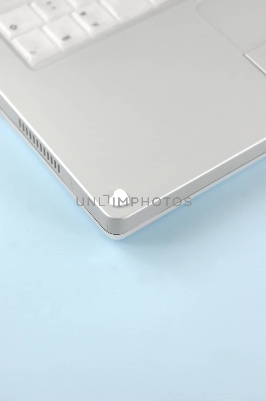 White foam heart on laptop. Online Love Concept, Pale Blue Background