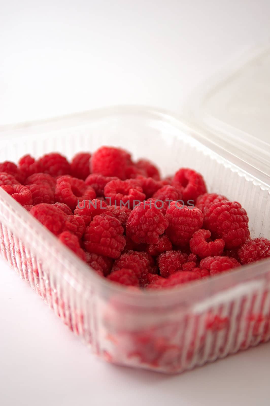 raspberries in plastic tray by maggiemolloy