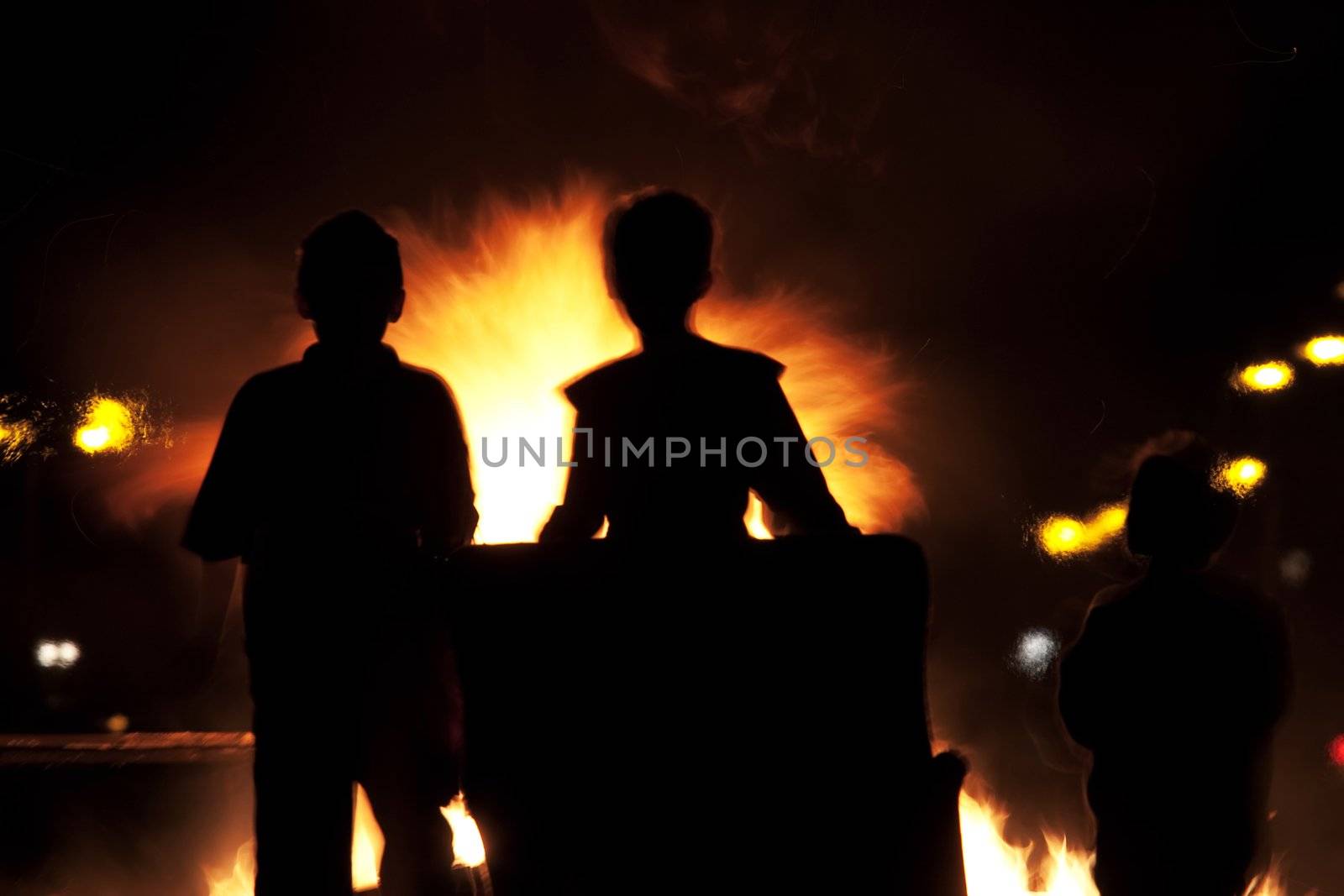 Children building a fire on Halloween evening set in silhouette