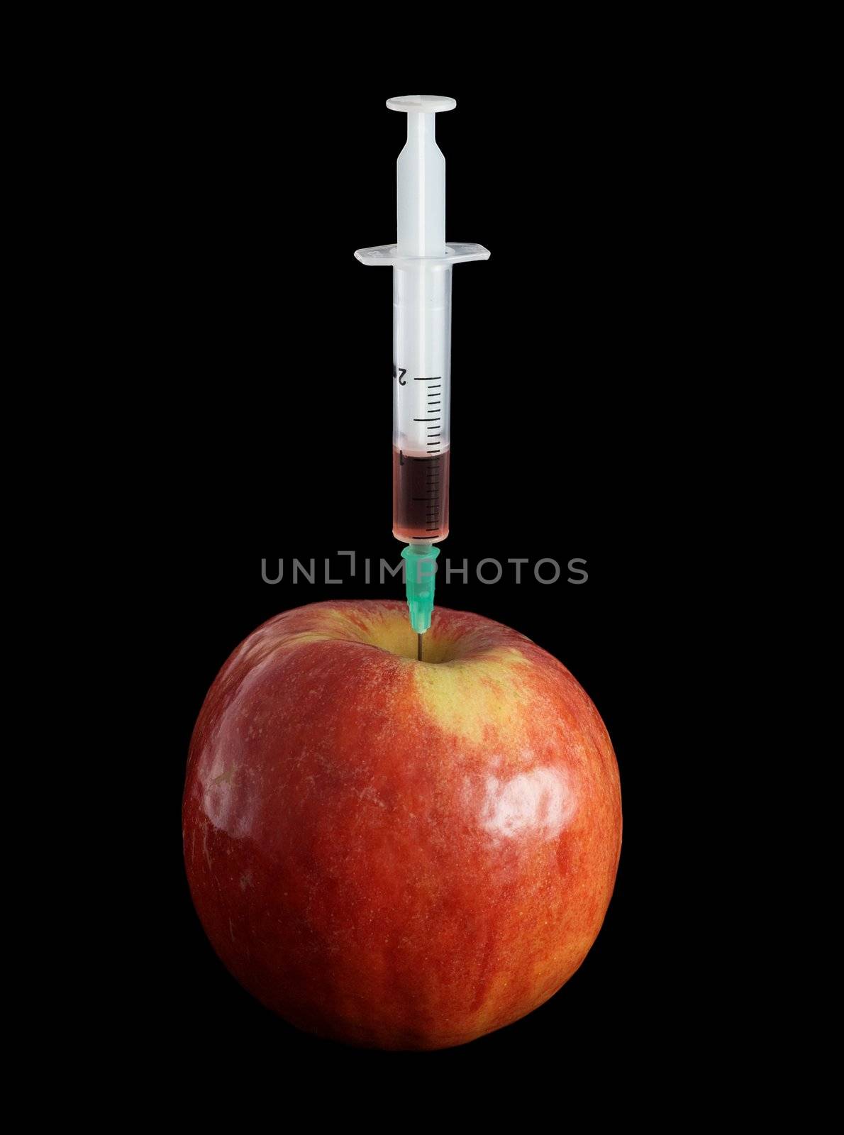 Apple with the thrust needle of a syringe in a soft flesh