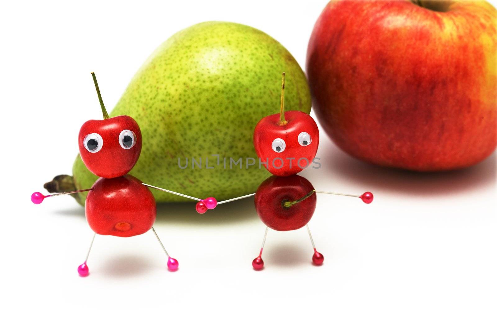 Two amusing little men from a sweet cherry on a background of a pear and an apple