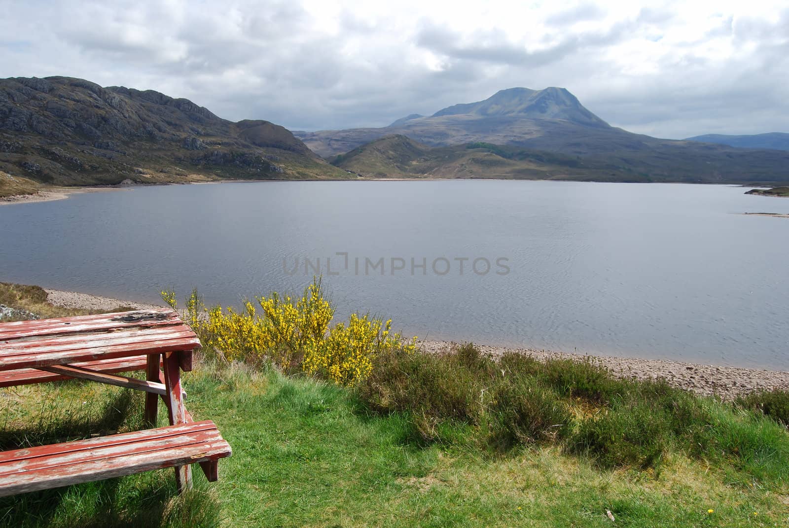 Picnic table at a beautiful lake surrounded by mountains