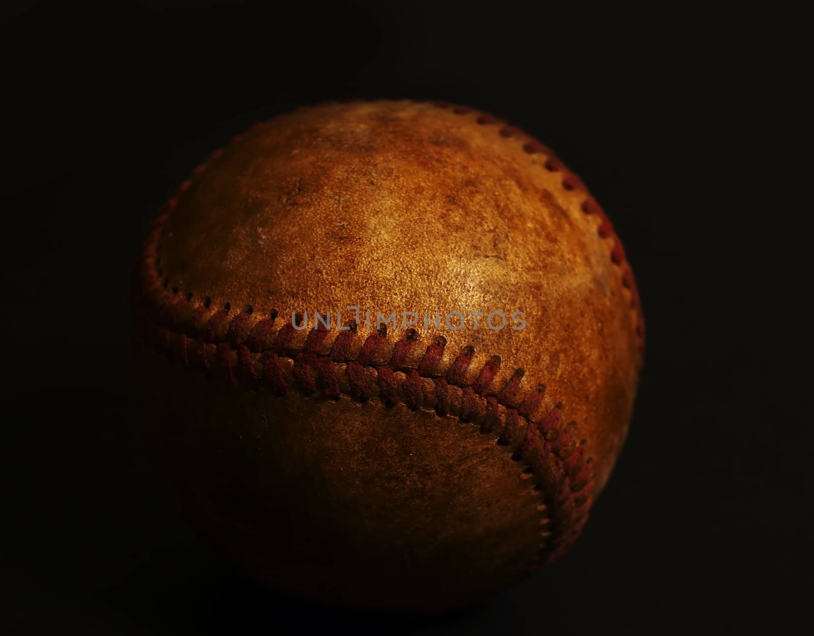 old worn baseball on black background