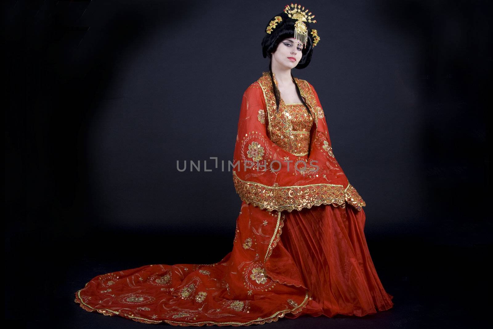 Portrait of an elegant asian princess dressed in golden and red with a crown. 