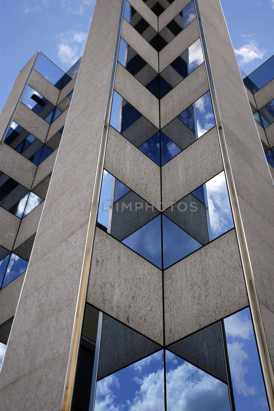 An office building in Switzerland reflecting the sky and clouds in its windows.
