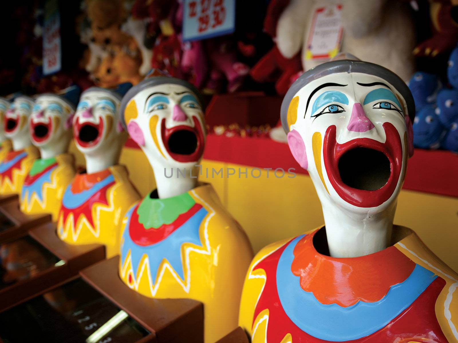 A row of clowns at an amusement park game.
