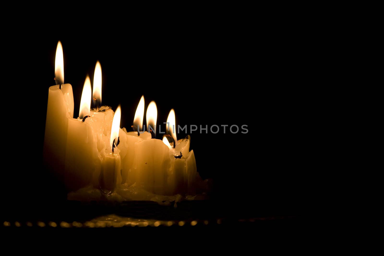 Group of white candles burning in the dark by jarenwicklund