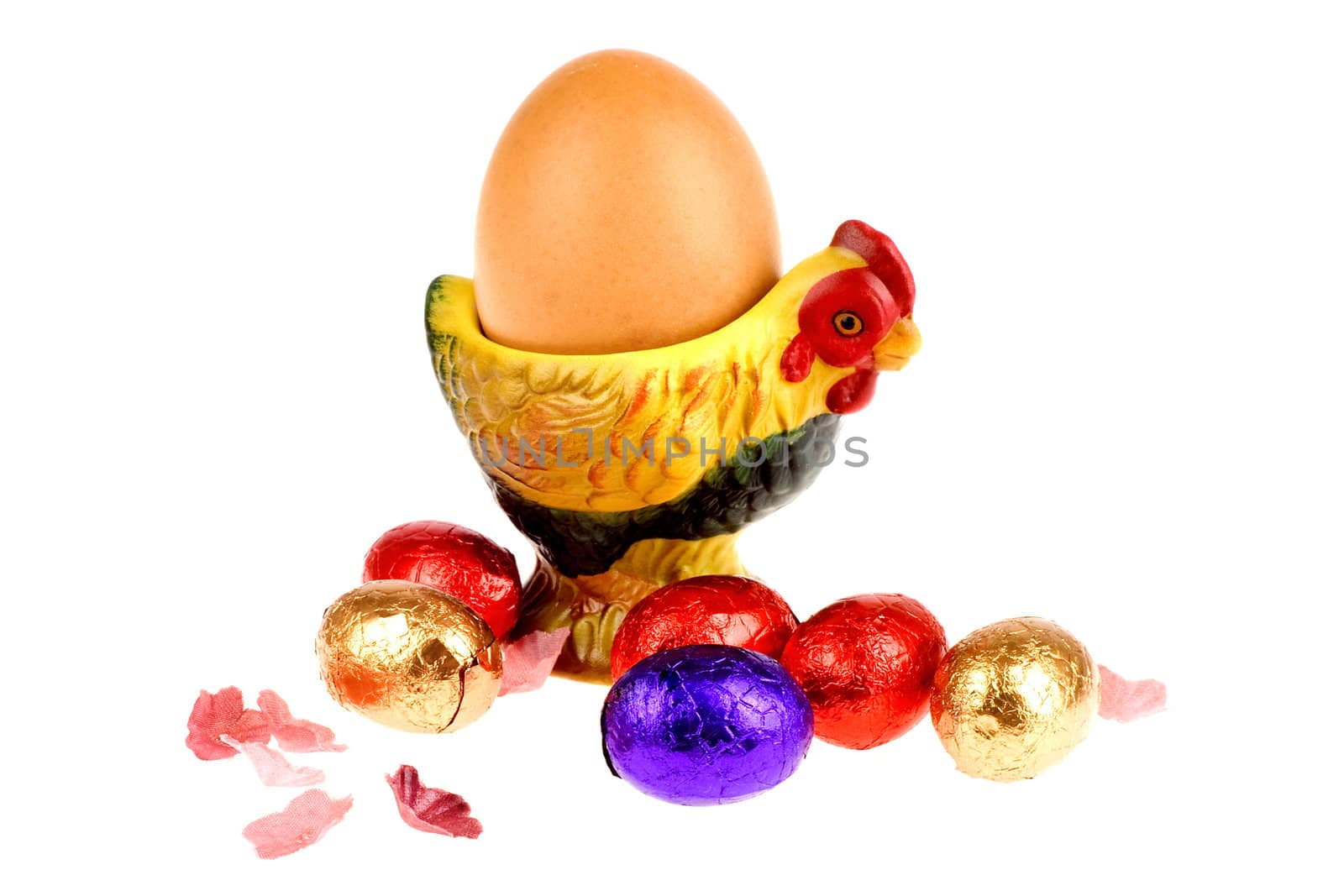 an egg in a egg cup with chocolate eggs