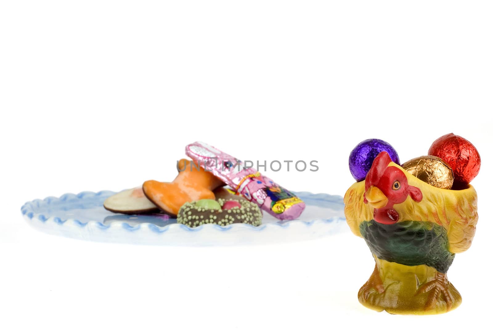 chocolate eggs in a egg cup with a plate on the back with chocolate candies