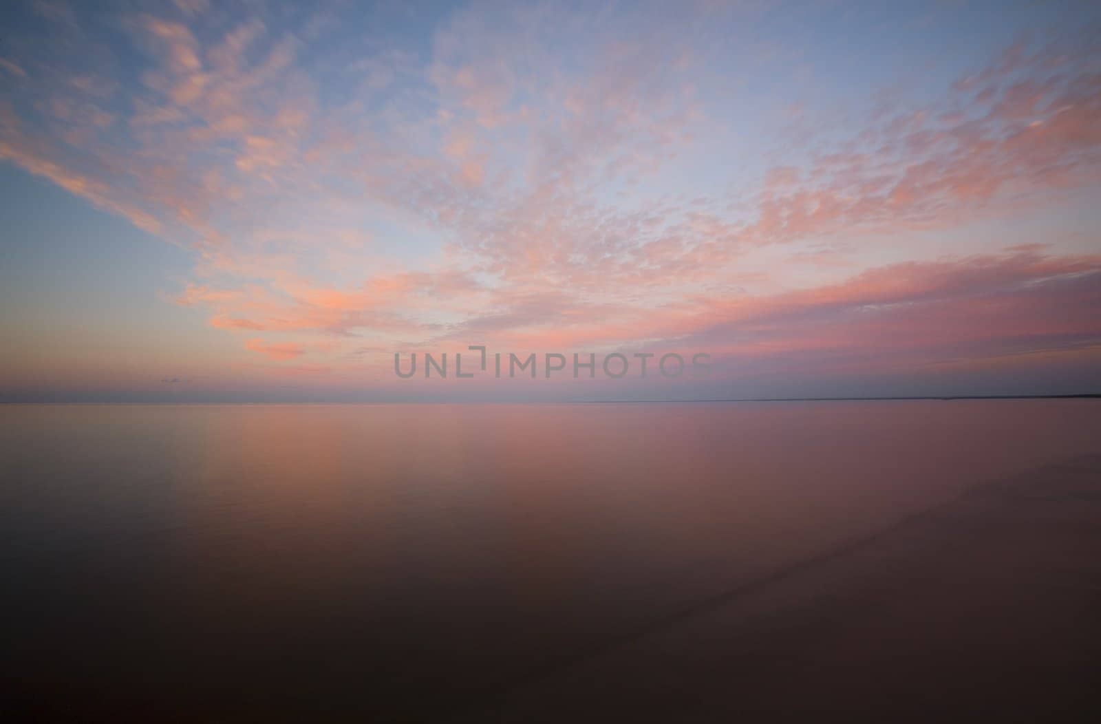 Sunset sky with clouds over the smooth water of Lake Superior.