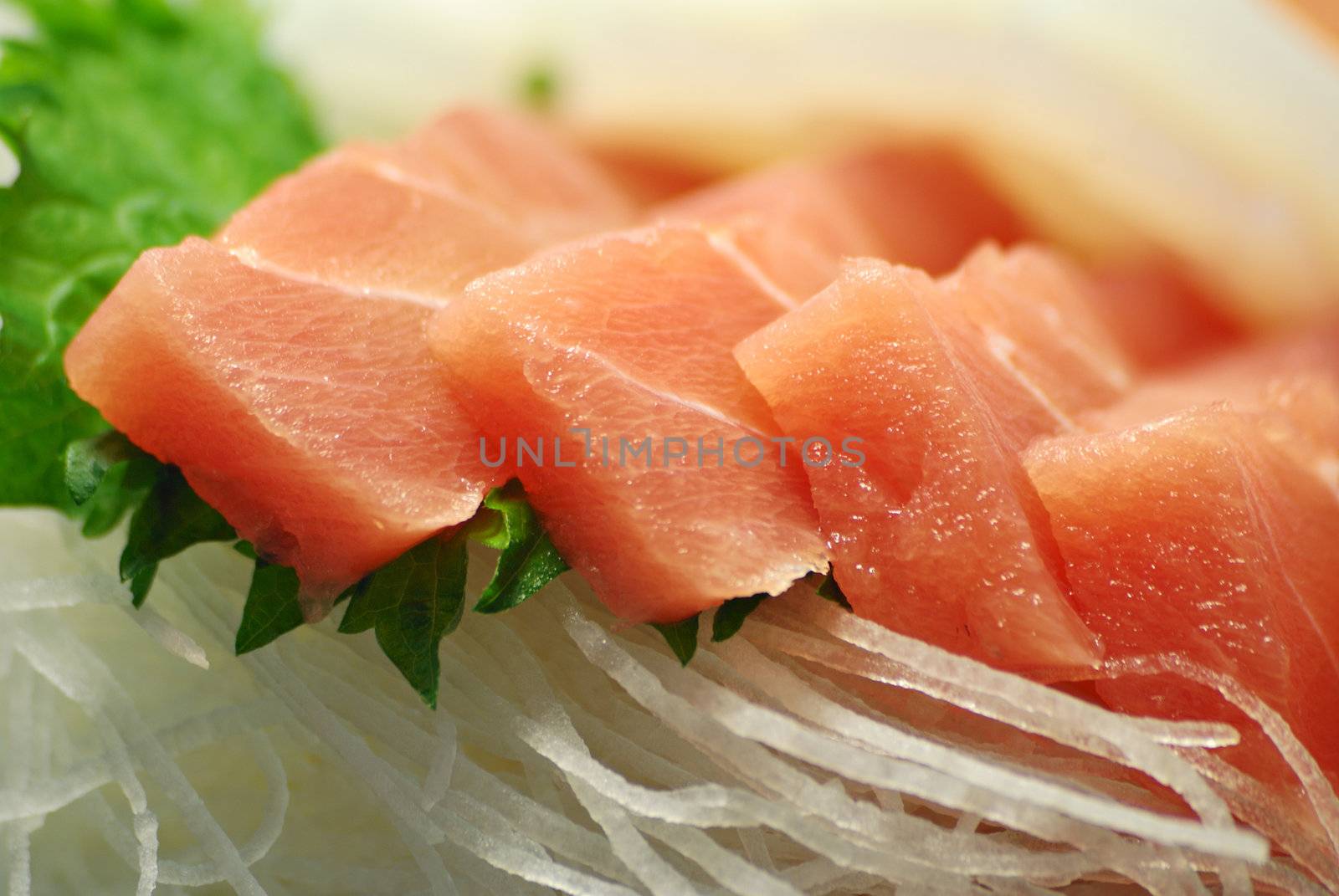  macro image of served Japanese raw fish food called sasimi; focus on front pieces