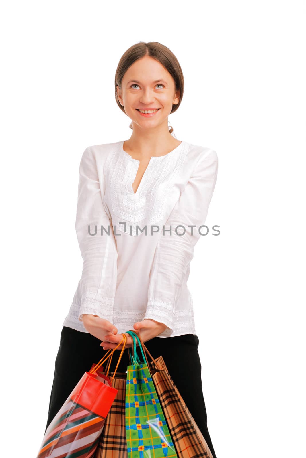 Pretty young female holding her shopping bags , looking away smiling isolated on white