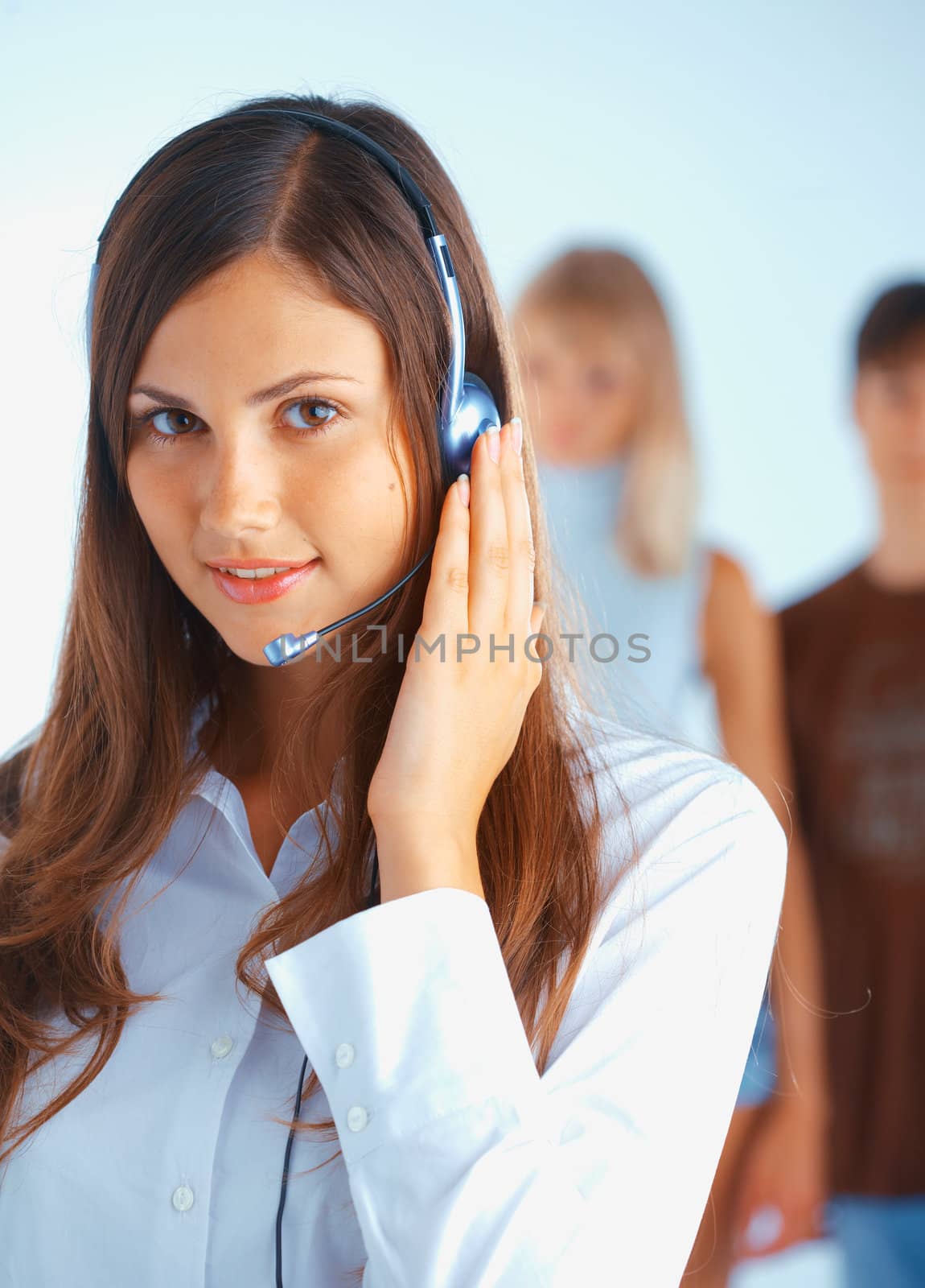 Young beautiful woman with headset with some people at the background
