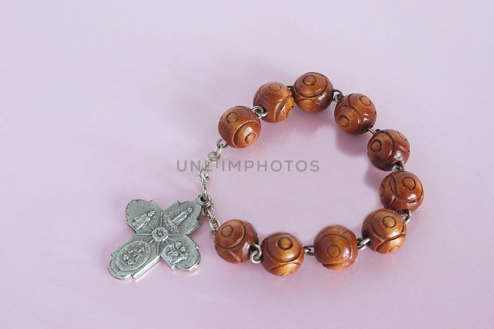 wooden crucifix rosary against a lilac background