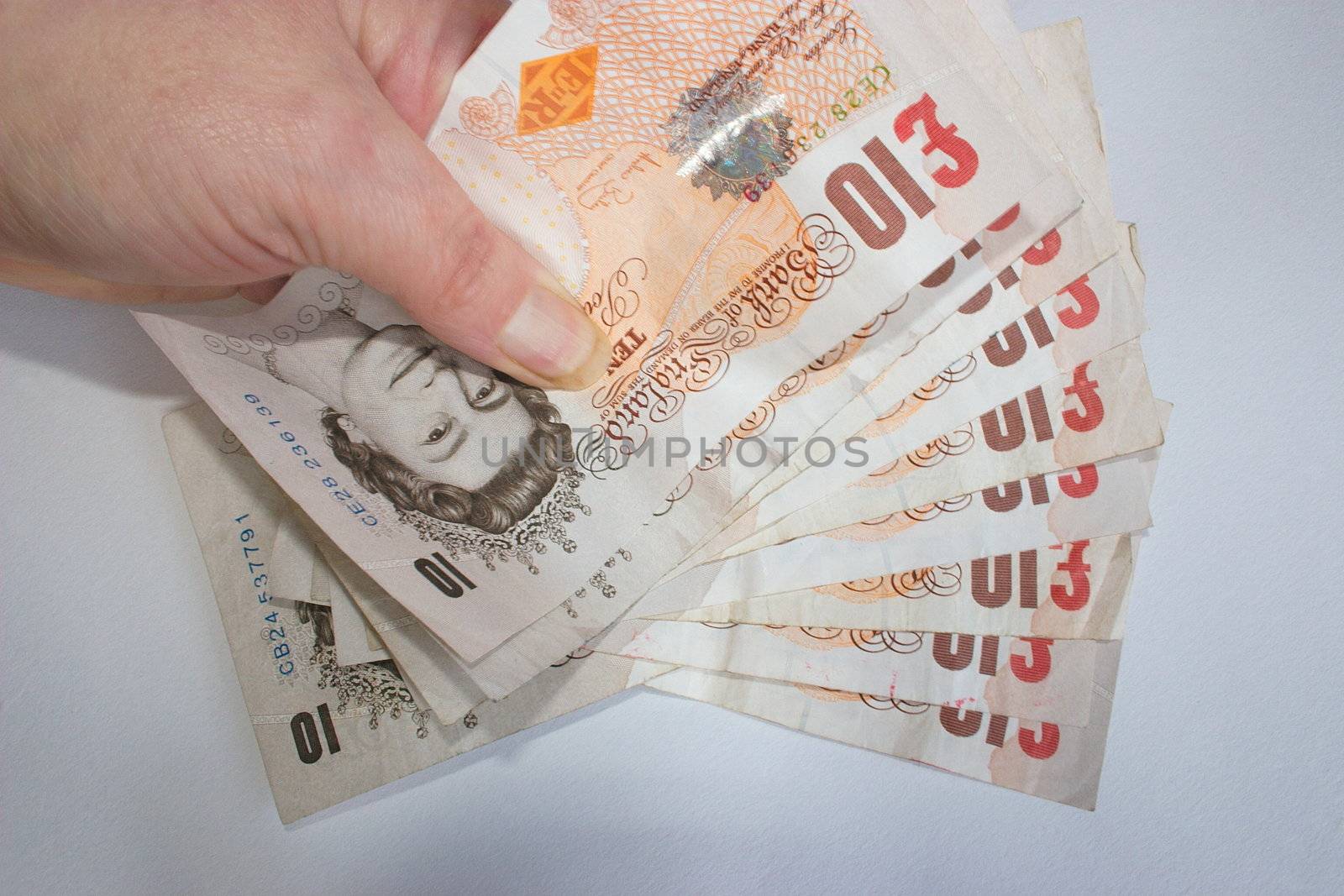 �100 in british sterling currency held in a hand