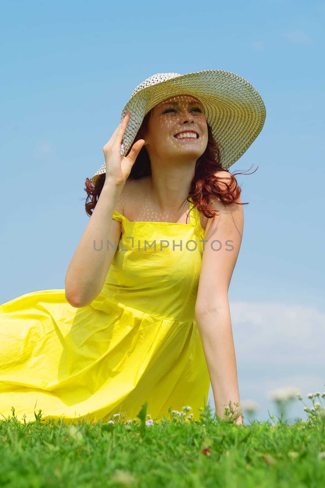 A beautiful girl on yellow dress and hat enjoying summer