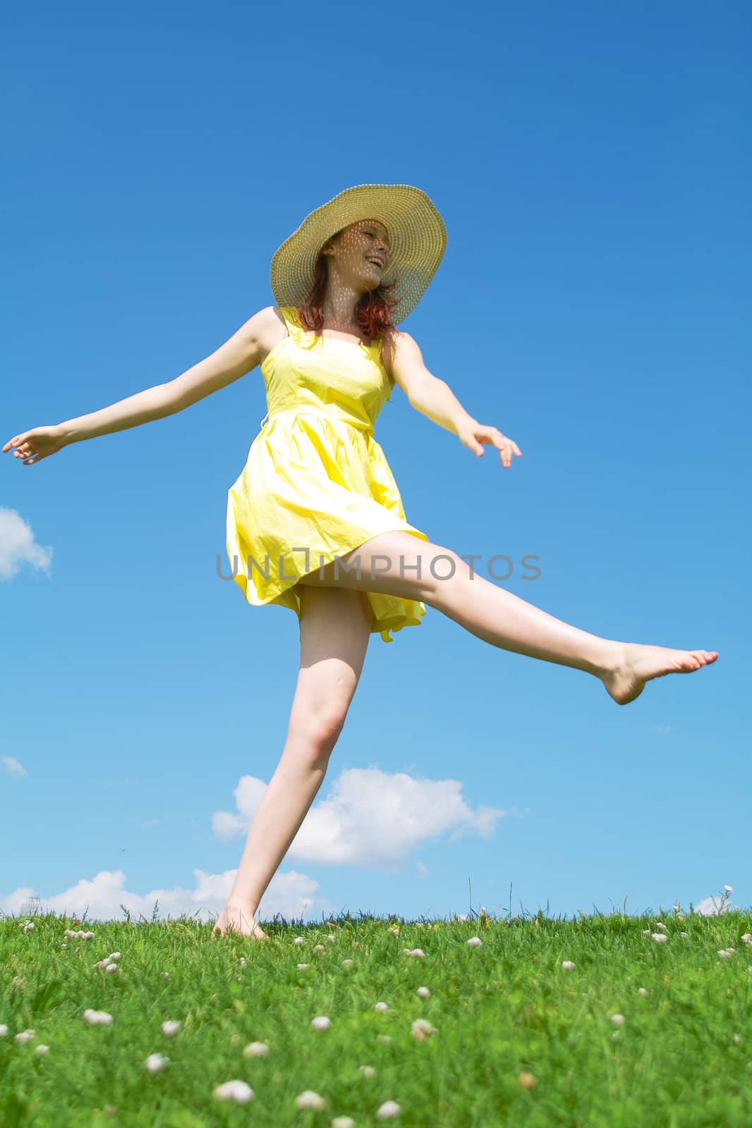 A beautiful girl on yellow dress and with red hair enjoying summer