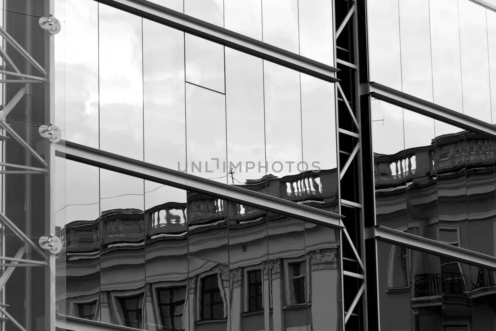 Old house reflected in modern building windows black and white