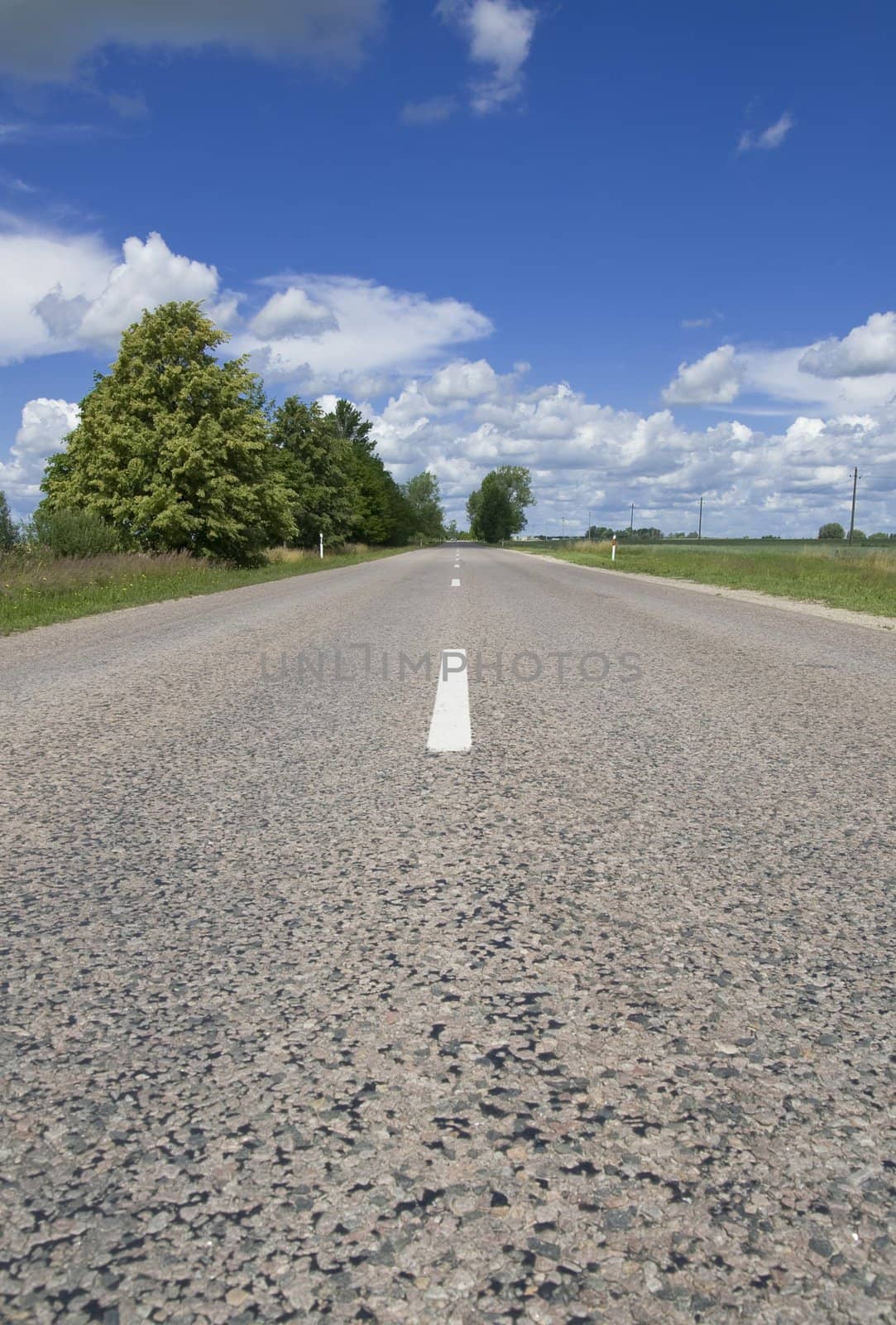 Summer landscape - empty highway, clouds and the blue sky