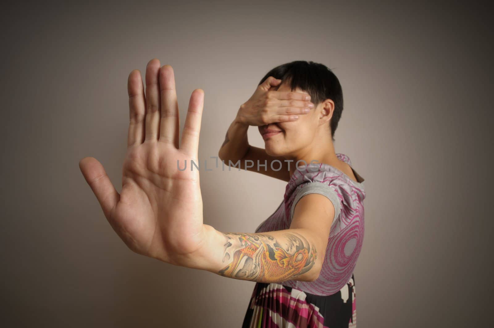 Woman with hands close eyes on gray background 