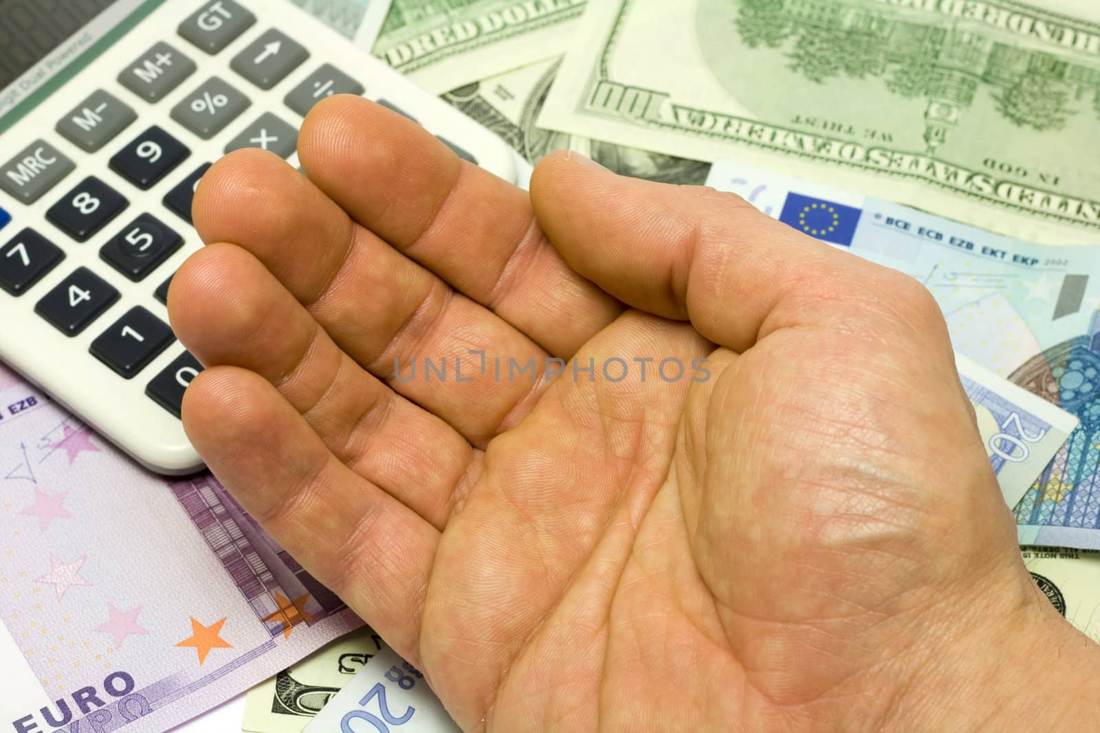 Dollar, euro banknotes, calculator and human hand