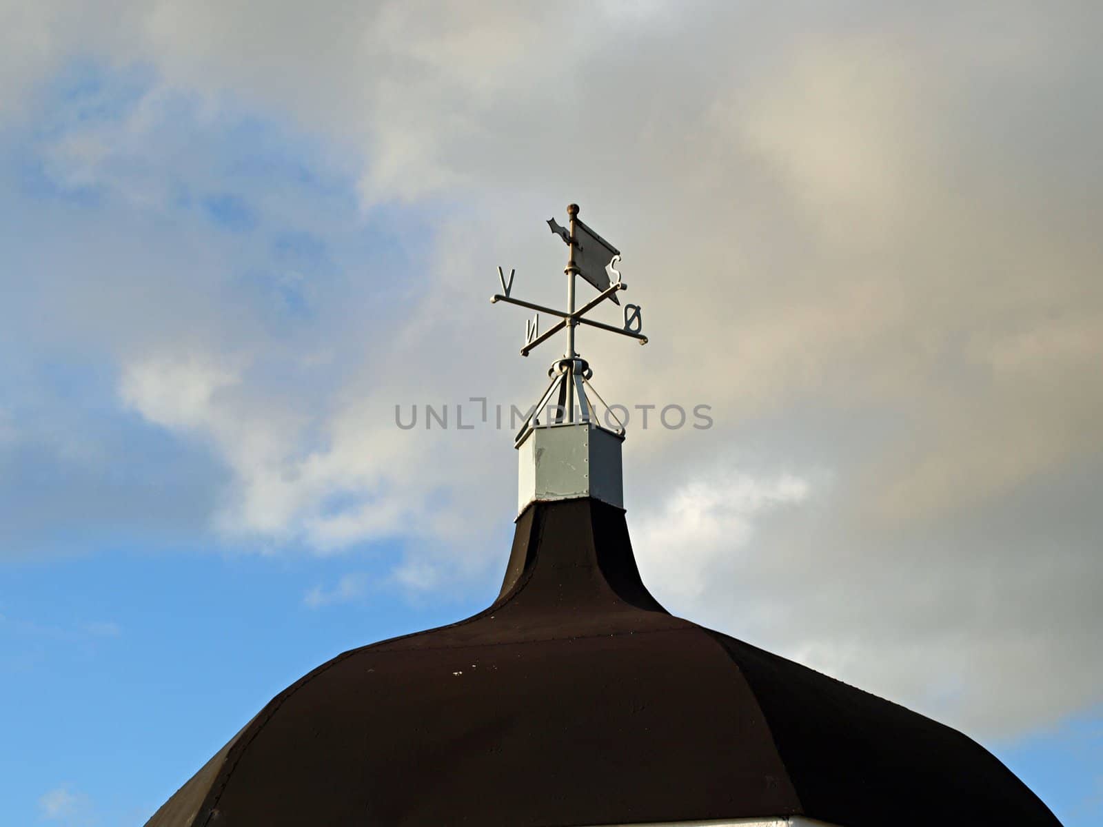 Traditional weathercock vane on a roof by Ronyzmbow