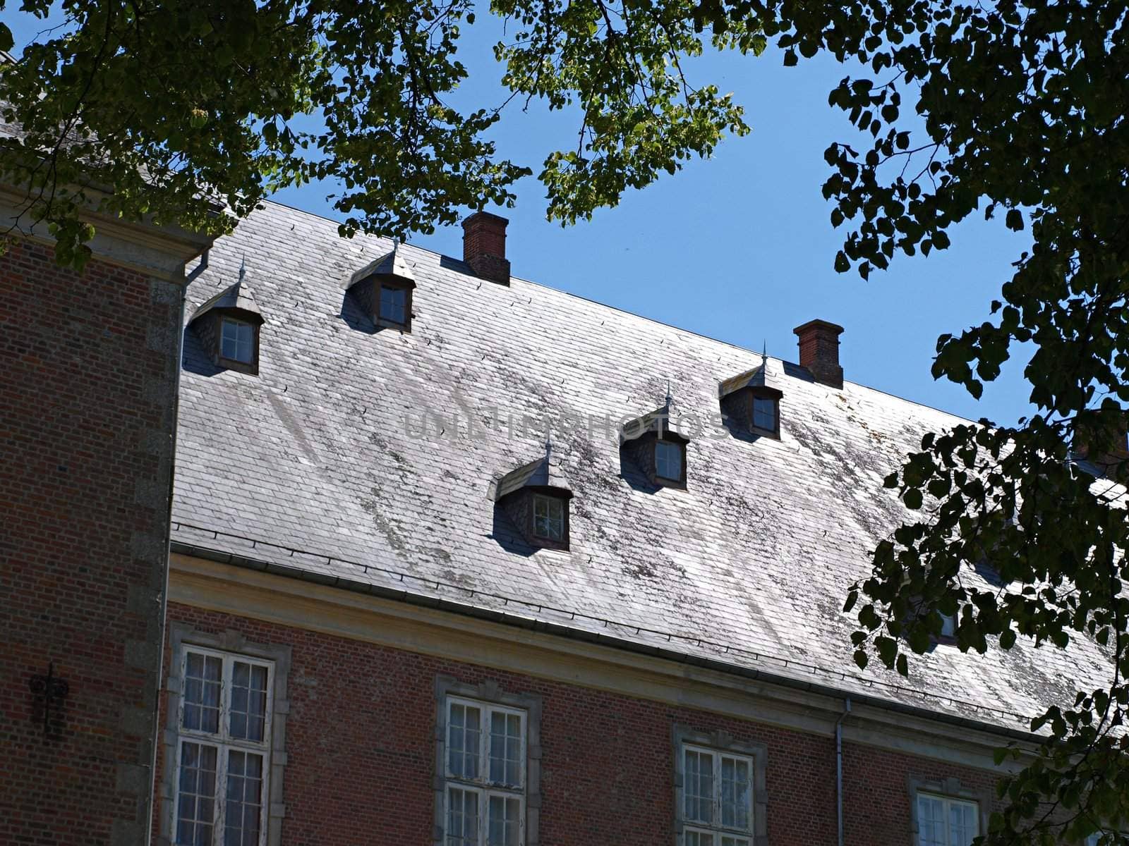 Big roof of a classical castle with attic windows dormer Denmark