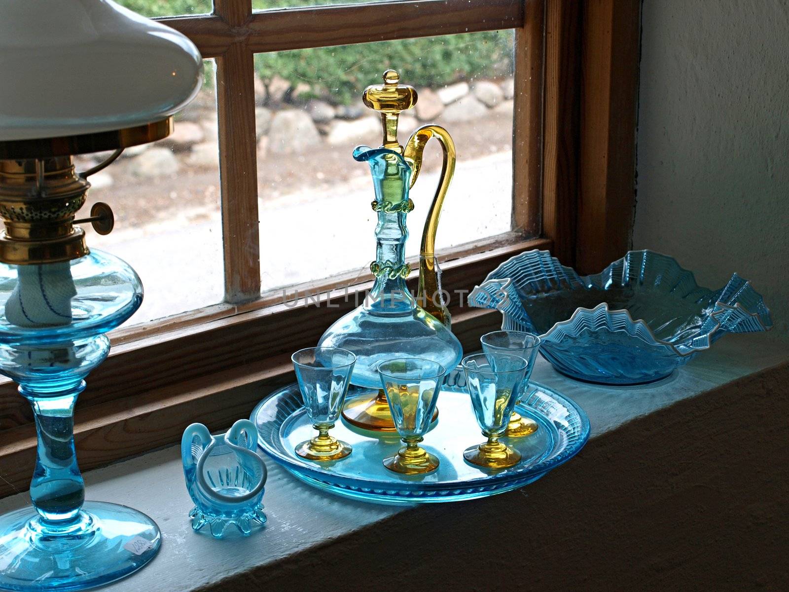 Beautiful decorative old glass items display by the window       
