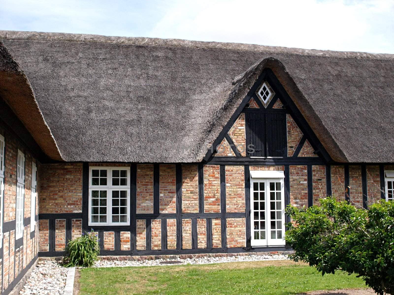 Traditional country farmhouse with old style thatched straw roof in Denmark       