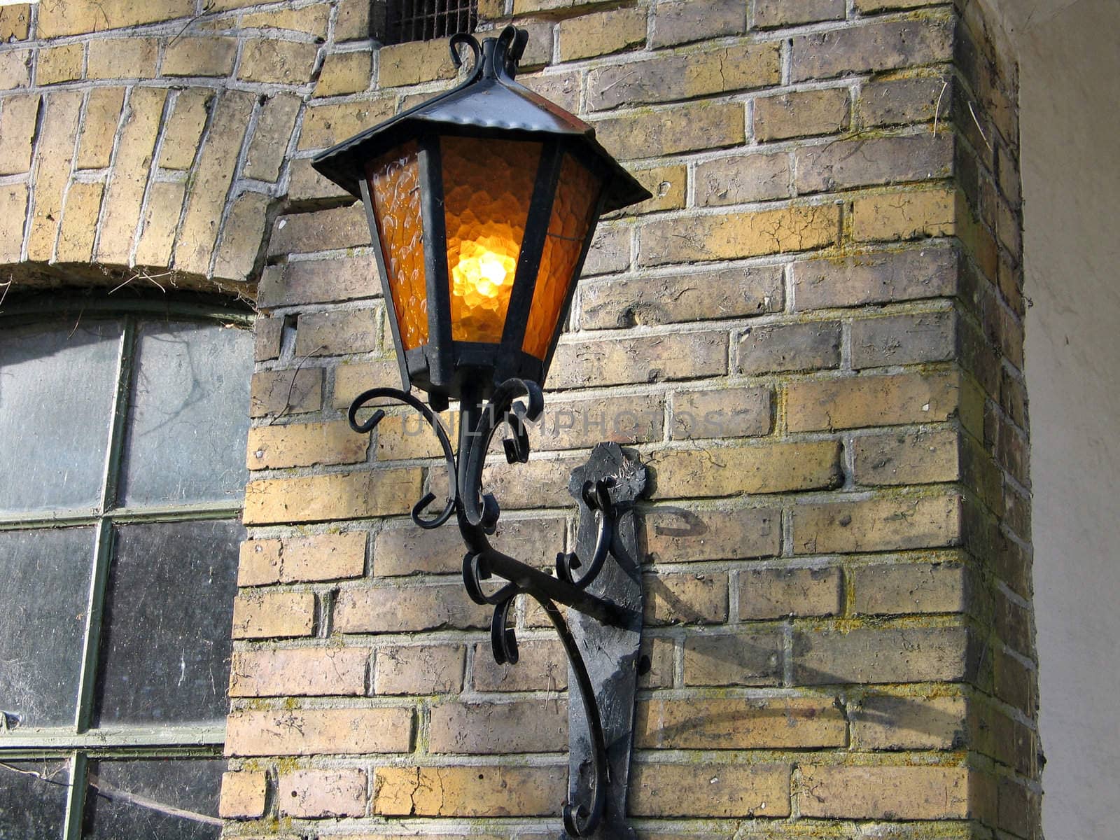 Old street lamp on bricks wall