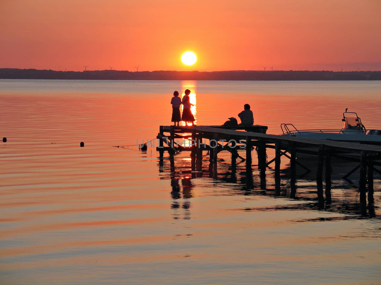 People on a dock in sunset in  a camping site in Langeland Denmark

