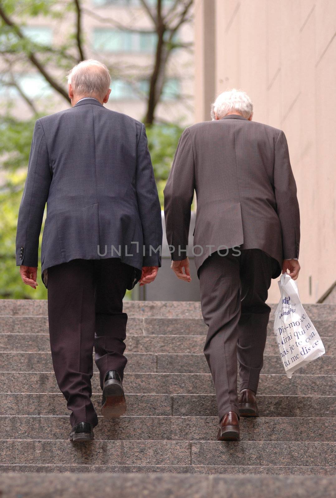 two old business man walking up the stairs