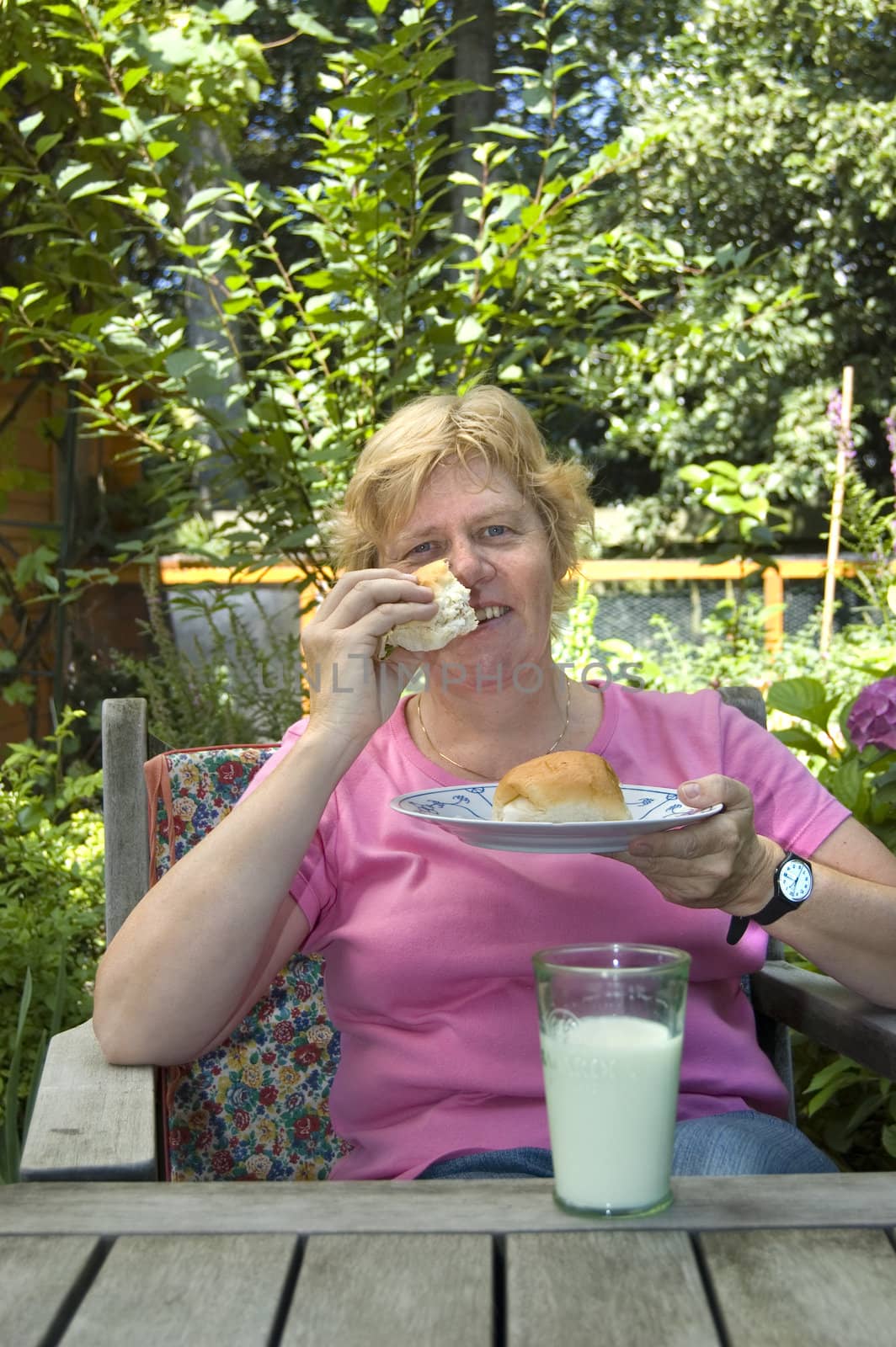 elderly woman is eating lunch in the garden