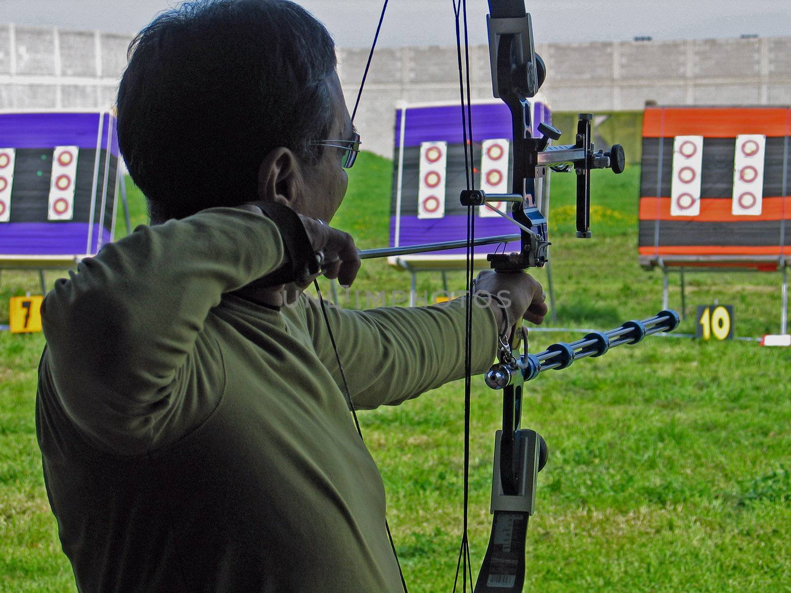 An archer shooting compound bow in archery competition