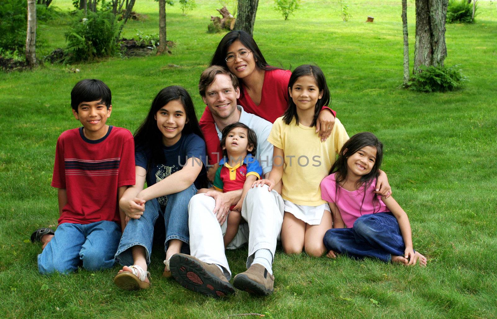 Happy multiracial family sitting on lawn