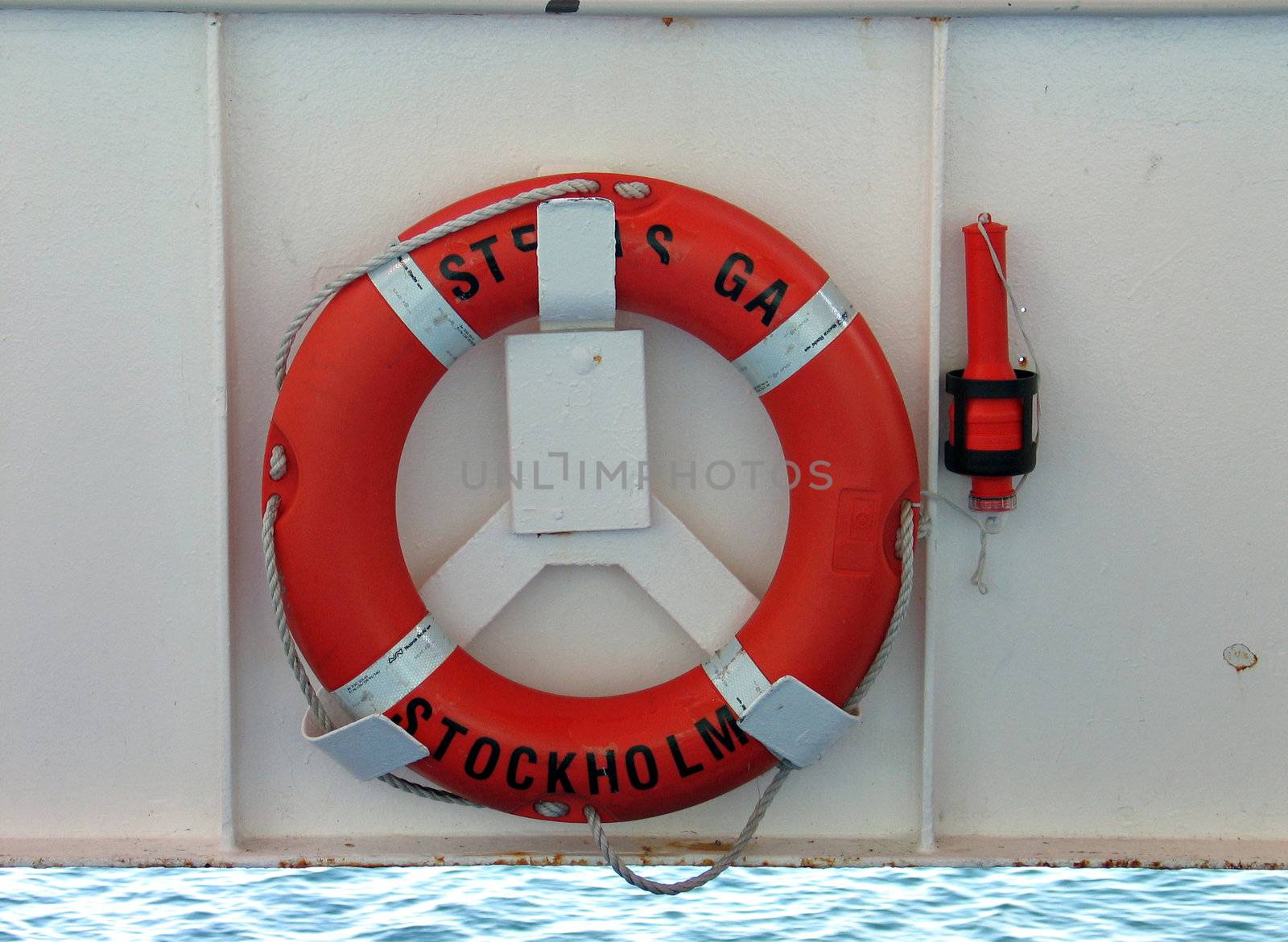 Lifering in bright orange color and safety light on a ship