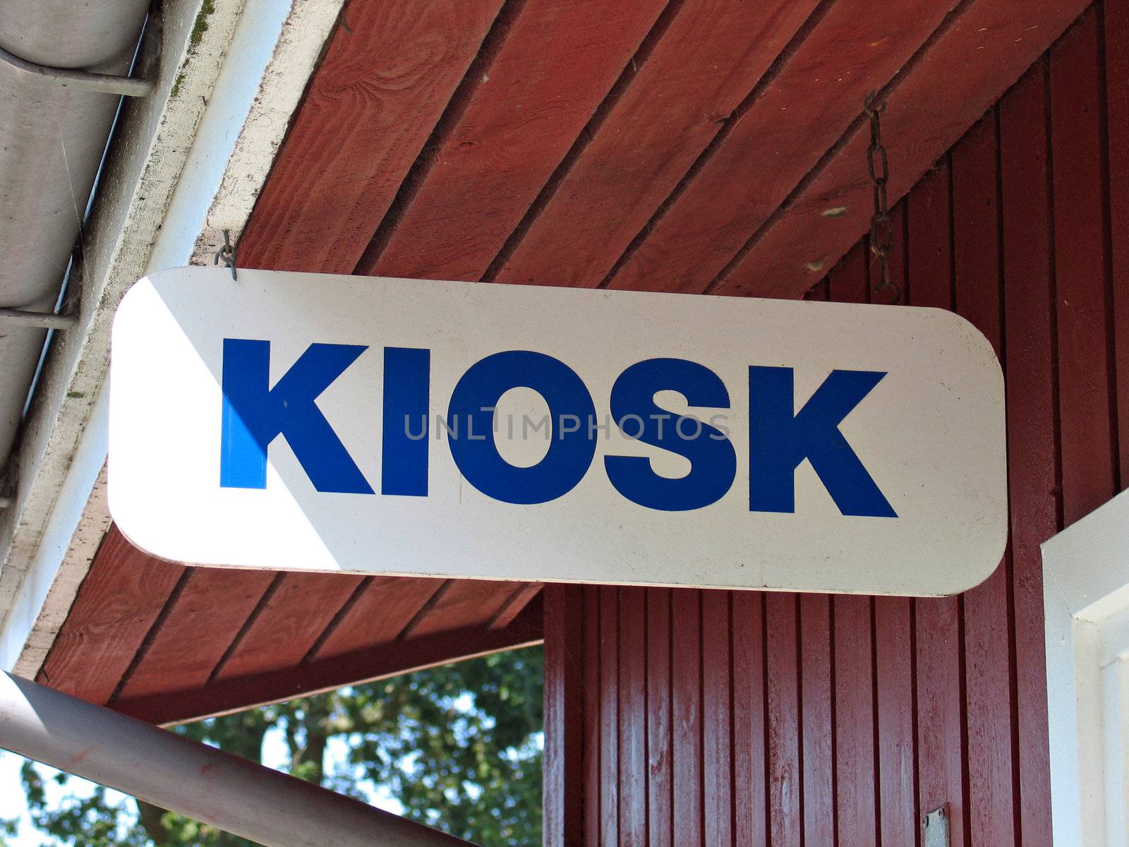 Sign of a kiosk hanged with metal wires from a wooden roof